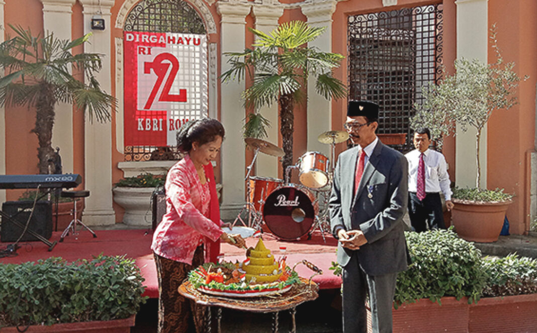 Esti Andayani dan Antonius Agus Sriyono memotong tumpeng HUT Kemerdekaan RI ke-72 di Roma majalah hidup katolik