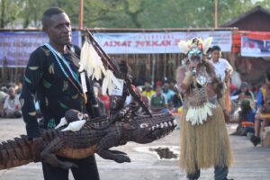 Emerickus Sarkol dengan bangga memperkenalkan salah satu seni ukir seniman Asmat di ajang lelang Festival Asmat Pokman 35. (HIDUP/Felicia Permata Hanggu)